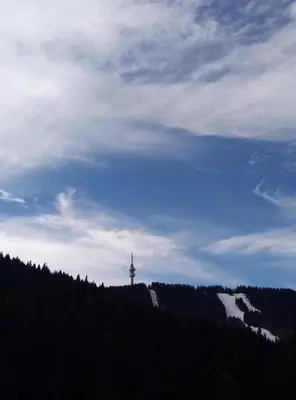 a lighthouse on top of a hill with a sky at Elza Apartment in Pamporovo