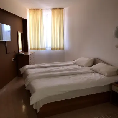 a bedroom with a large white bed with a window at Apartment Lucy in Pamporovo