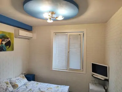 a bedroom with a ceiling fan and a bed and a window at Стаи за гости Ве-Бо-Ли** in Bankya