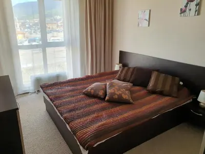 a bedroom with a large bed with a large window at Koko's apartments in Bansko