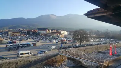 a parking lot with a bunch of cars parked at Koko's apartments in Bansko