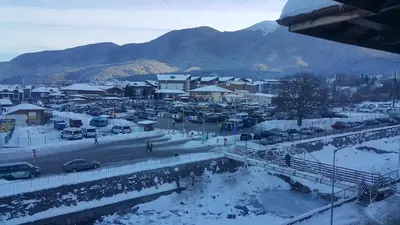 a town in the snow with cars parked at Koko's apartments in Bansko