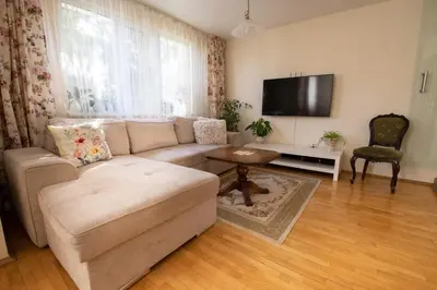a living room with a couch and a flat screen tv at Cosy, quiet house with Vitosha view near Paradise in Sofia
