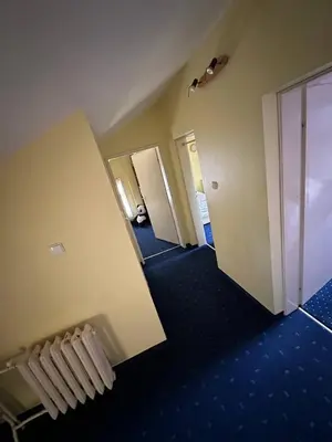 an empty hallway of a hotel room with blue carpet at Cosy, quiet house with Vitosha view near Paradise in Sofia