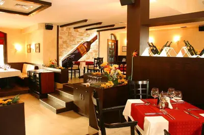 a restaurant with a table with a red table cloth at Hotel Domaine Peshtera in Peshtera
