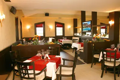 a restaurant with tables and chairs and a bar at Hotel Domaine Peshtera in Peshtera