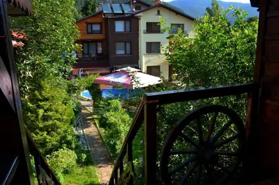 a view of a balcony with an umbrella and a house at Семеен хотел Калина Family hotel Kalina Говедарци in Govedartsi