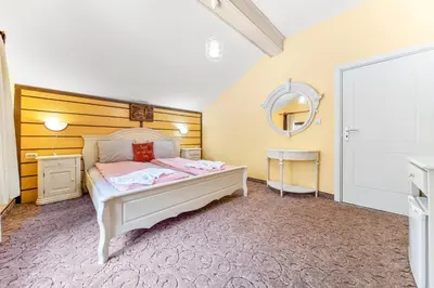 a bedroom with a white bed and a mirror at House Shiligarnika in Bansko