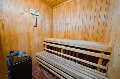 a wooden sauna with a bench and a trash can at House Shiligarnika in Bansko