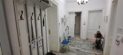 a hallway with white doors and a blue chair at Modern and Old Base in Sofia