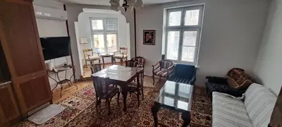 a living room with a table and a couch at Modern and Old Base in Sofia