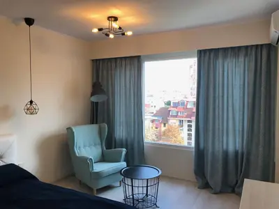 a bedroom with a blue chair and a window at Apartment 