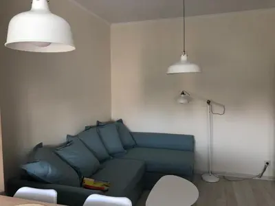 a living room with a blue couch and two lights at Apartment 