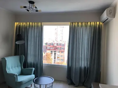 a room with a chair and a large window at Apartment 