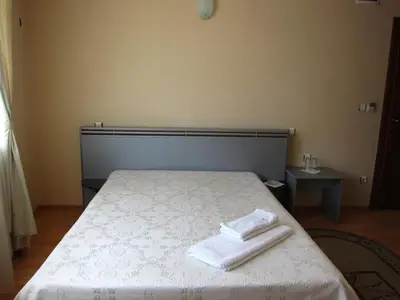 a bedroom with a bed with two towels on it at Family Hotel Bistritsa in Sandanski