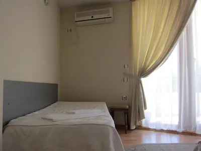 a bedroom with a bed and a window at Family Hotel Bistritsa in Sandanski