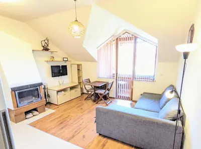 a living room with a couch and a tv at Casual Apartment near Gondola & City Center - Neon in Bansko