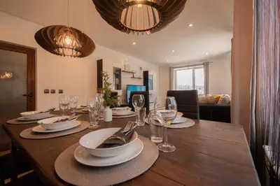 a dining room table with plates and wine glasses at Hyggemate - 2 Bed Room Warm Stay in Sarnitsa in Sarnitsa