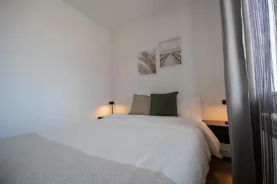 a white bed in a bedroom with two pictures on the wall at Hyggemate - 2 Bed Room Warm Stay in Sarnitsa in Sarnitsa