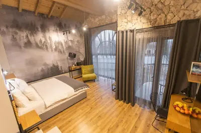 a bedroom with a bed and a table and a chair at Villa Sintica in Sandanski