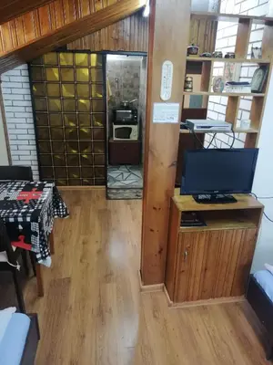 a room with a desk with a television and a kitchen at Guest Room Asparuh in Troyan