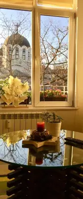 a table in a room with a window and a table sidx sidx sidx at Sweet home in the heart of Sofia in Sofia
