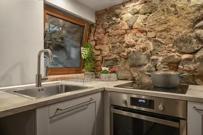 a kitchen with a sink and a stone wall at The White House Sofia in Sofia