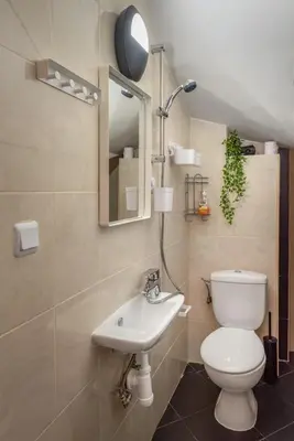 a bathroom with a toilet and a sink and a mirror at The White House Sofia in Sofia
