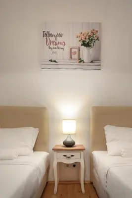 a room with two beds and a table with a lamp at The White House Sofia in Sofia