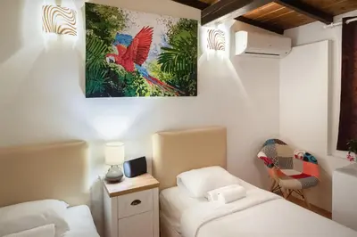 a bedroom with two beds and a painting on the wall at The White House Sofia in Sofia