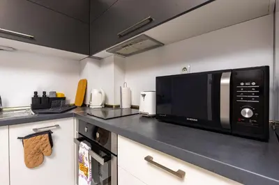 a kitchen with a microwave and a black counter top at Apartment Valerie walking distance to Top Center in Plovdiv