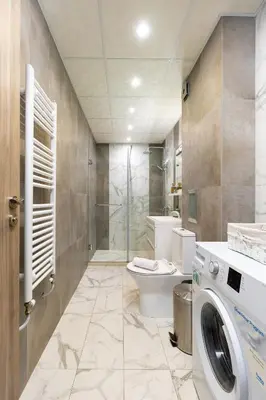 a bathroom with a toilet and a washing machine at Apartment Valerie walking distance to Top Center in Plovdiv