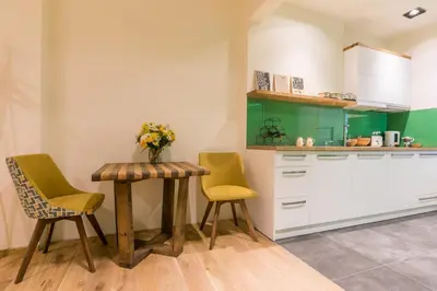 a kitchen with two chairs and a table with a vase of flowers at Este Apart - Top center in Sofia