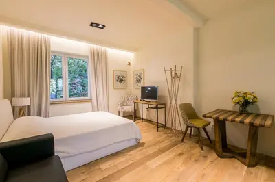 a bedroom with a bed and a desk with a computer at Este Apart - Top center in Sofia