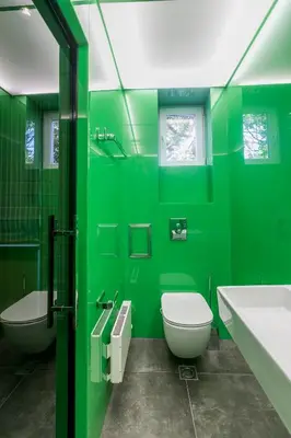 a green bathroom with a toilet and a sink at Este Apart - Top center in Sofia