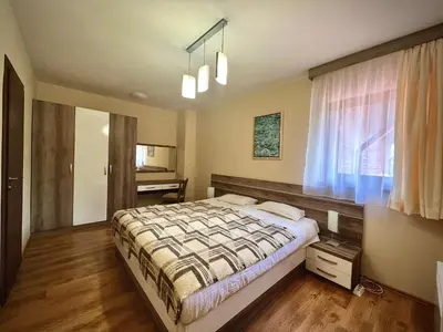 a bedroom with a bed and a window at RELAX aпартаменти, Смолянски езера, вила ВЕНЕРА, к-с Маунтин Лейк in Smolyan