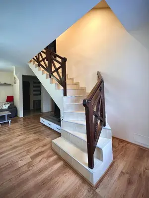 a staircase in a living room with a wooden floor at RELAX aпартаменти, Смолянски езера, вила ВЕНЕРА, к-с Маунтин Лейк in Smolyan