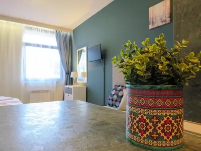 a large vase with a plant on a table at Rivendell Apartments Flora Complex in Borovets