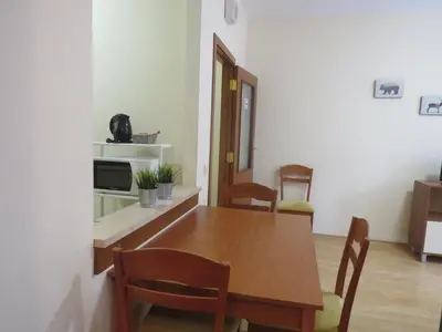 a dining room with a wooden table and chairs at Rivendell Apartments Flora Complex in Borovets