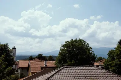 a view from the roof of a town with a clock tower at Guest house Legeto in Samokov