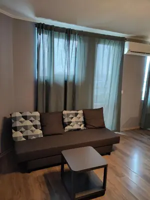 a living room with a couch and a table at Mladost 1 Apartment near the metro in Sofia