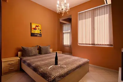 a bedroom with a bed and a chandelier at Family Hotel Marsina in Sofia