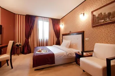 a hotel room with a bed and a chair at Best Western Plus Bristol Hotel in Sofia