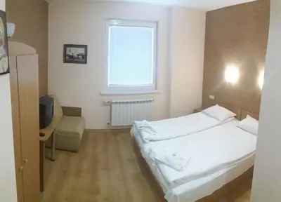 a bedroom with a white bed and a window at Comfort Guest House in Samokov