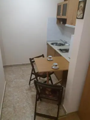 a small kitchen with a table and two chairs at Comfort Guest House in Samokov