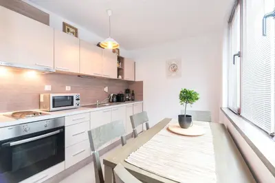 a kitchen with white cabinets and a table with a plant on it at ★ Chic & Elegant 1 Bedroom in Eagle's Nest Complex ★ Close to Gondola and Bar Street in Bansko