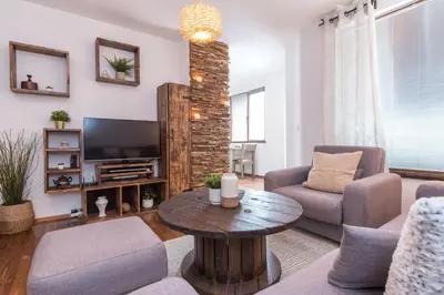a living room with a couch and a table and a tv at ★ Chic & Elegant 1 Bedroom in Eagle's Nest Complex ★ Close to Gondola and Bar Street in Bansko