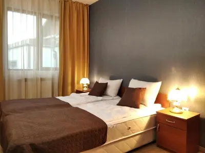 a bedroom with a large bed with two night stands at private apartments Emerald in Bansko