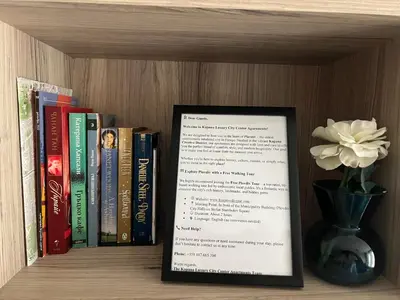 a book shelf with a sign and a vase with a flower at Kapana Luxury City Center Apartments with Garage in Plovdiv