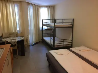 a room with two bunk beds and a table and a desk at Studio Villa Park 119 in Borovets